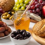 مائدة طعام متنوعة تضم التمر والزيتون والعسل والفاكهة وفق المنهج النبوي
