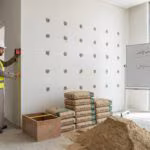 مهندس يقيس سُمك محارة جدار لحساب كمية الإسمنت والرمل